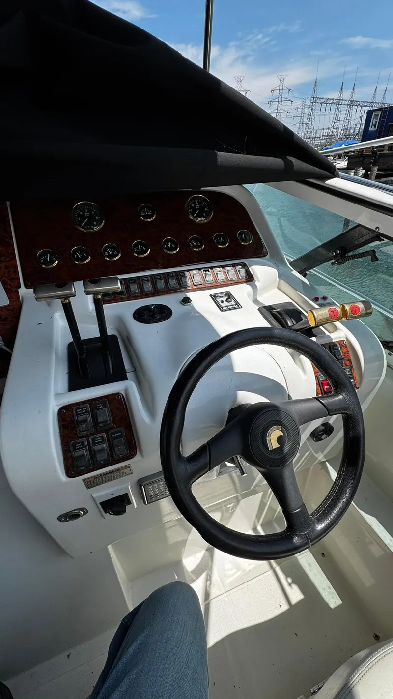 Slide: The Image of 1999 Trojan 40 Express boat helm with steering wheel and control panel. - 2