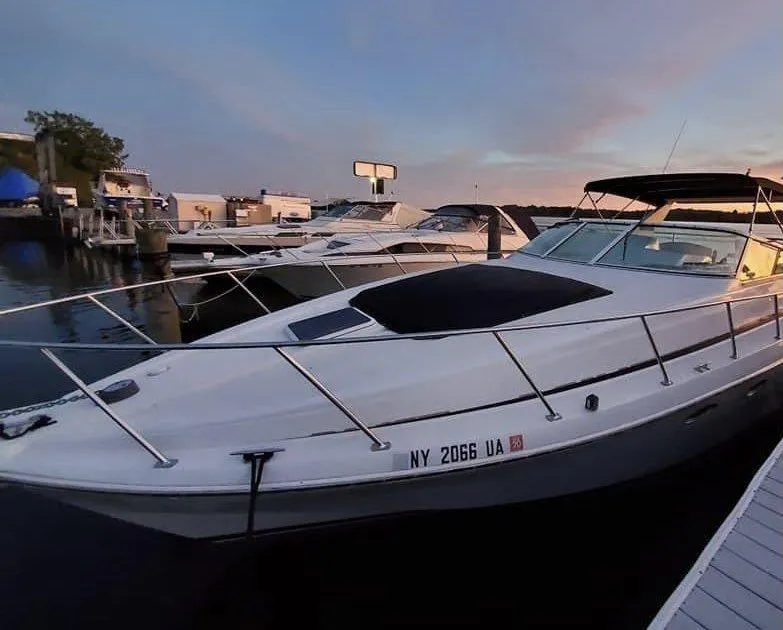 Slide: The Image of 1999 Trojan 40 Express yacht docked at sunset, featuring sleek design and modern amenities. - 5