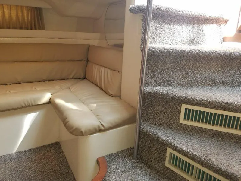 Slide: The Image of Interior of 1999 Trojan 40 Express yacht with beige seating and carpeted stairs. - 7