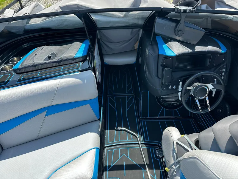 Slide: The Image of 2021 Centurion Fi25 boat interior with modern dashboard and blue-accented seating. - 7
