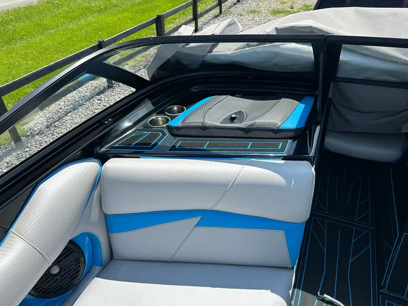 Slide: The Image of 2021 Centurion Fi25 boat interior with blue and gray seating, cup holders, and sleek design. - 9