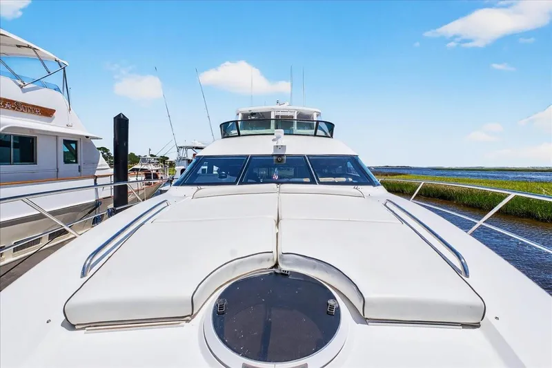 Slide: The Image of 2004 Neptunus 56 Flybridge yacht docked, showcasing sleek design and spacious deck. - 10