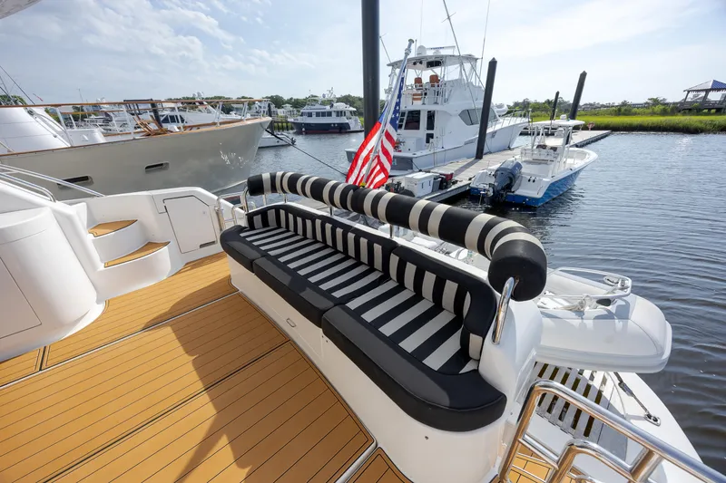 Slide: The Image of Luxurious 2004 Neptunus 56 Flybridge yacht with striped seating, docked at marina. - 12