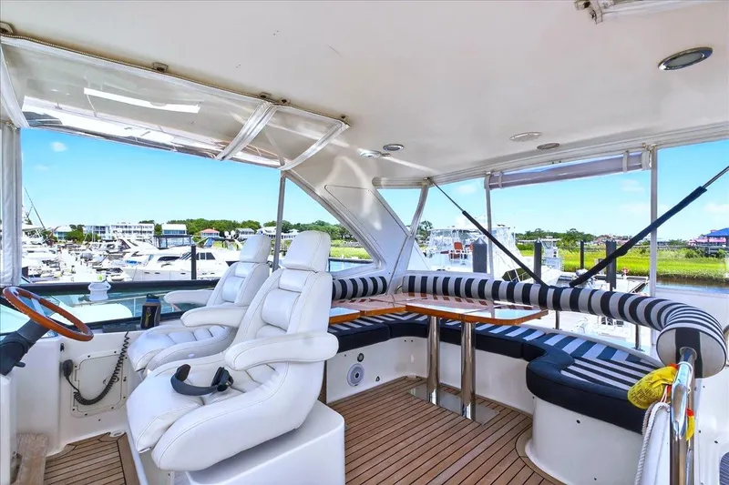 Slide: The Image of Luxurious 2004 Neptunus 56 Flybridge yacht interior with plush seating and scenic marina view. - 19