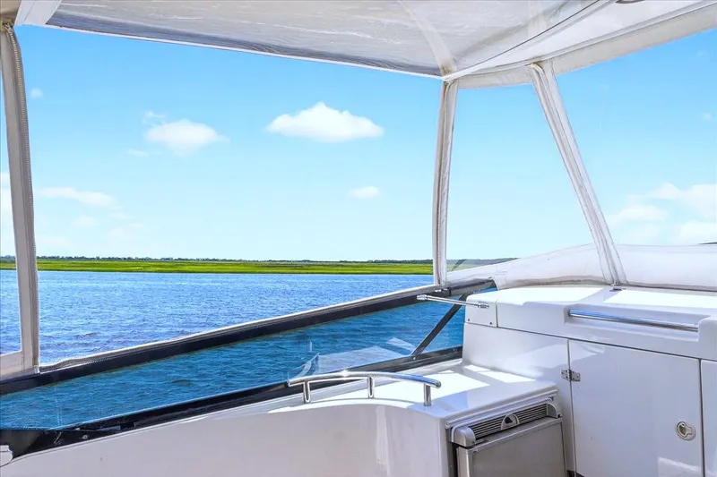 Slide: The Image of View from 2004 Neptunus 56 Flybridge yacht, overlooking serene blue waters and clear sky. - 27
