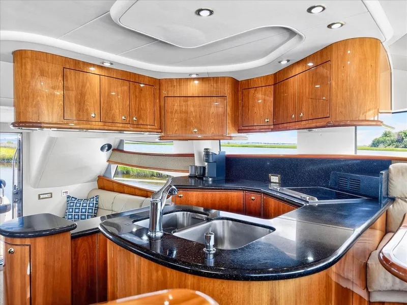 Slide: The Image of Luxurious 2004 Neptunus 56 Flybridge yacht interior with sleek kitchen and wooden cabinetry. - 33