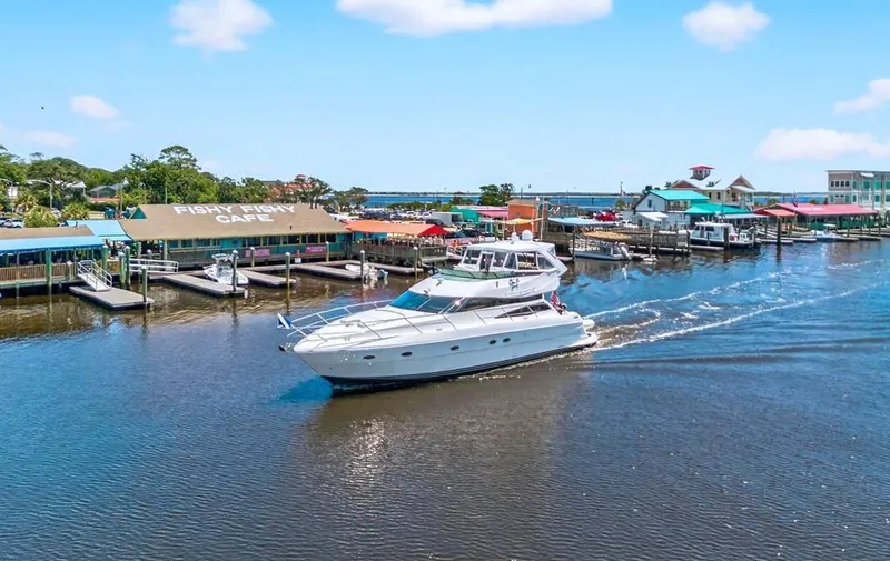 Slide: The Image of 2004 Neptunus 56 Flybridge yacht cruising near colorful waterfront cafes. - 4