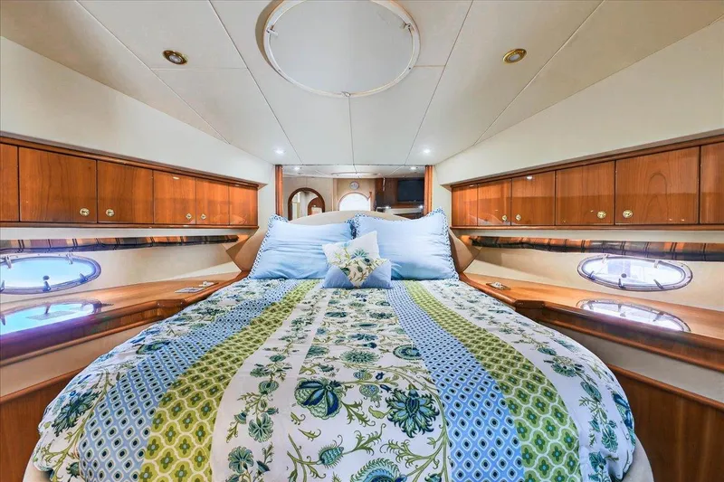 Slide: The Image of Luxurious 2004 Neptunus 56 Flybridge yacht bedroom with elegant bedding and wood cabinetry. - 48