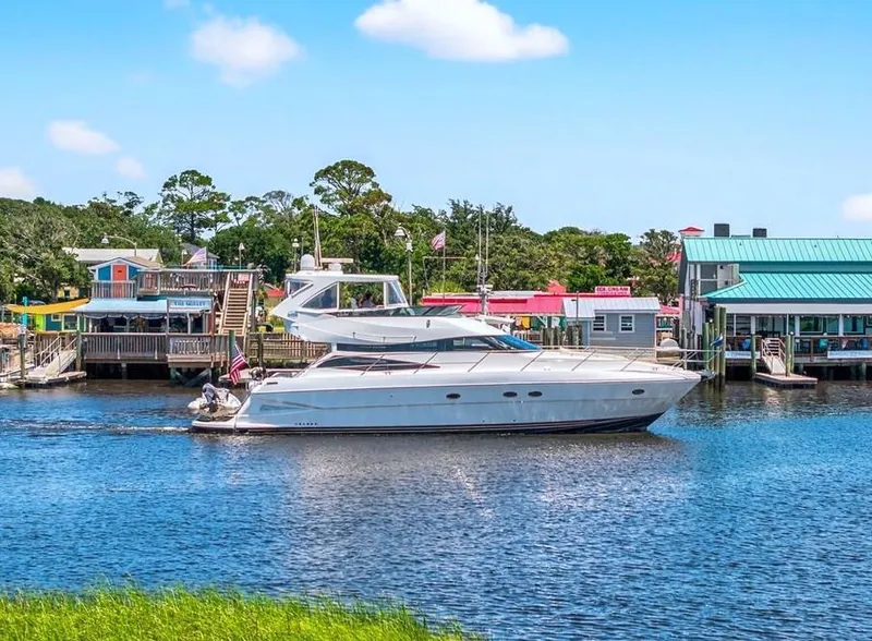 Slide: The Image of 2004 Neptunus 56 Flybridge yacht cruising near colorful waterfront buildings. - 5