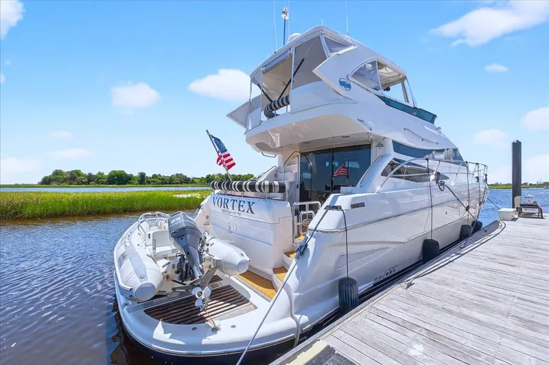 Slide: The Image of 2004 Neptunus 56 Flybridge yacht docked, featuring sleek design and American flag. - 9