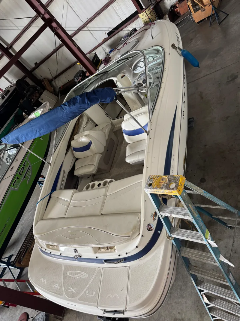 Slide: The Image of 2004 Maxum 2100 SC boat in a garage, viewed from above with a ladder nearby. - 1