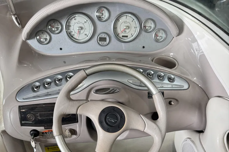 Slide: The Image of 2004 Maxum 2100 SC boat dashboard with gauges, steering wheel, and control switches. - 5
