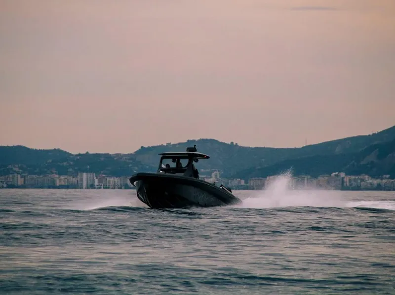 Slide: The Image of 2026 Skipper-BSK 42 boat speeding on water with cityscape and hills in the background. - 4