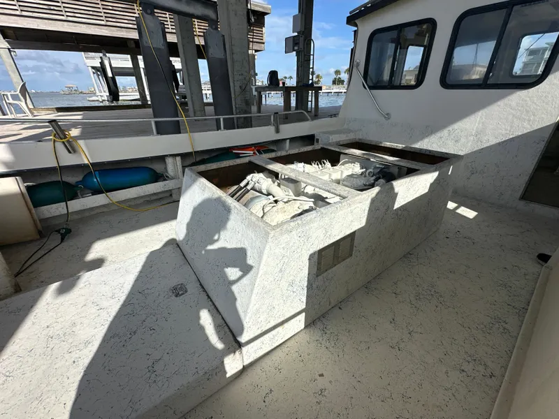 Slide: The Image of 2004 Jefferson Fiberglass 32 Laffite Skiff docked, showcasing open engine compartment and deck details. - 19