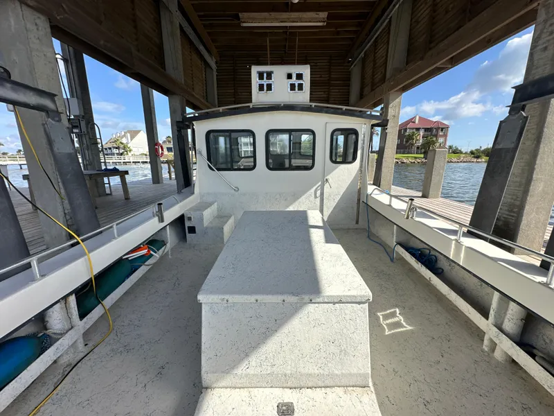 Slide: The Image of Custom 2004 Jefferson Fiberglass 32 Laffite Skiff docked under a wooden shelter. - 22