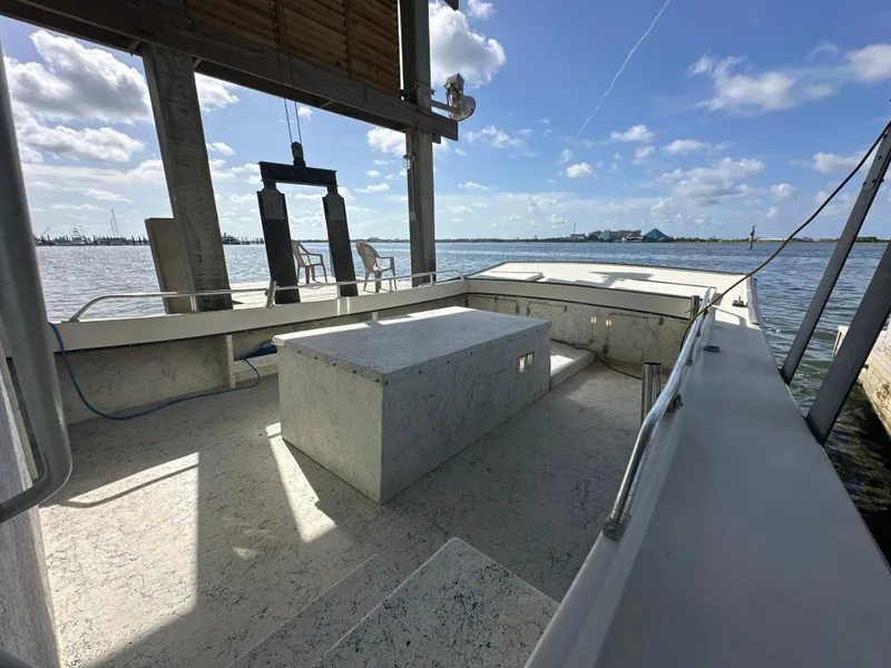 Slide: The Image of 2004 Jefferson Fiberglass 32 Laffite Skiff docked, featuring spacious deck and scenic waterfront view. - 24