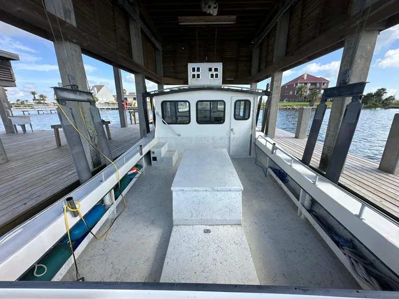 Slide: The Image of 2004 Jefferson Fiberglass 32 Laffite Skiff docked under a wooden shelter. - 25