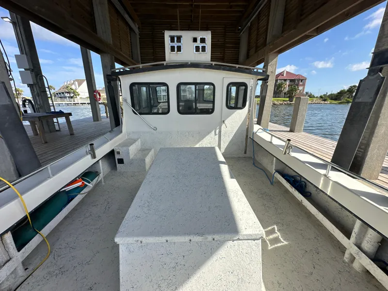 Slide: The Image of 2004 Jefferson Fiberglass 32 Laffite Skiff docked under a wooden shelter. - 27