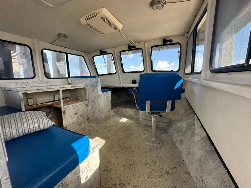 Slide: The Image of Interior of 2004 Jefferson Fiberglass 32 Laffite Skiff with blue seating and large windows. - 29