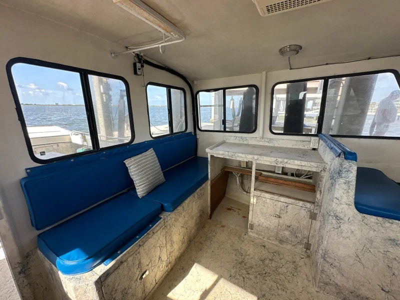 Slide: The Image of Interior of 2004 Jefferson Fiberglass 32 Laffite Skiff with blue seating and waterfront view. - 30