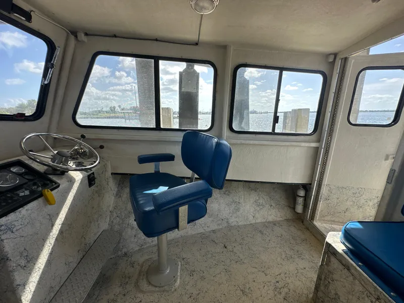 Slide: The Image of Interior of 2004 Jefferson Fiberglass 32 Laffite Skiff with blue captain's chair and steering wheel. - 32