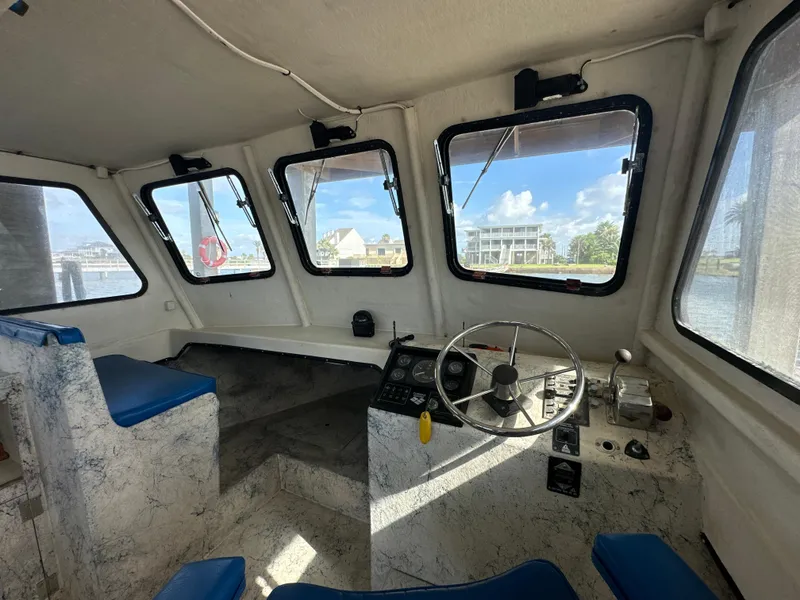 Slide: The Image of Interior of 2004 Jefferson Fiberglass 32 Laffite Skiff with steering wheel and blue seating. - 33