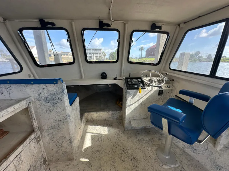Slide: The Image of Interior of 2004 Jefferson Fiberglass 32 Laffite Skiff with blue seating and steering console. - 34