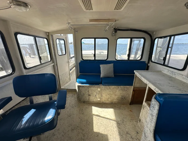 Slide: The Image of Interior of 2004 Jefferson Fiberglass 32 Laffite Skiff with blue seating and waterfront view. - 38