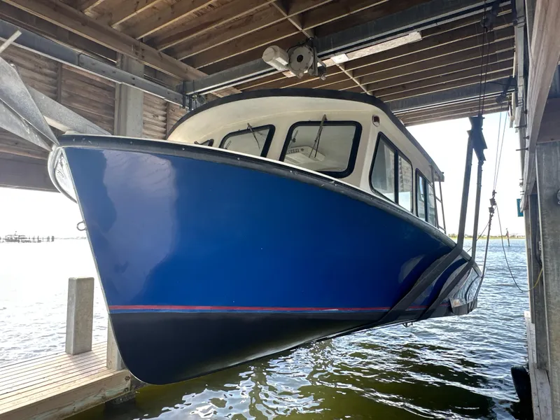 Slide: The Image of Blue 2004 Jefferson Fiberglass 32 Laffite Skiff boat suspended in a boathouse. - 4