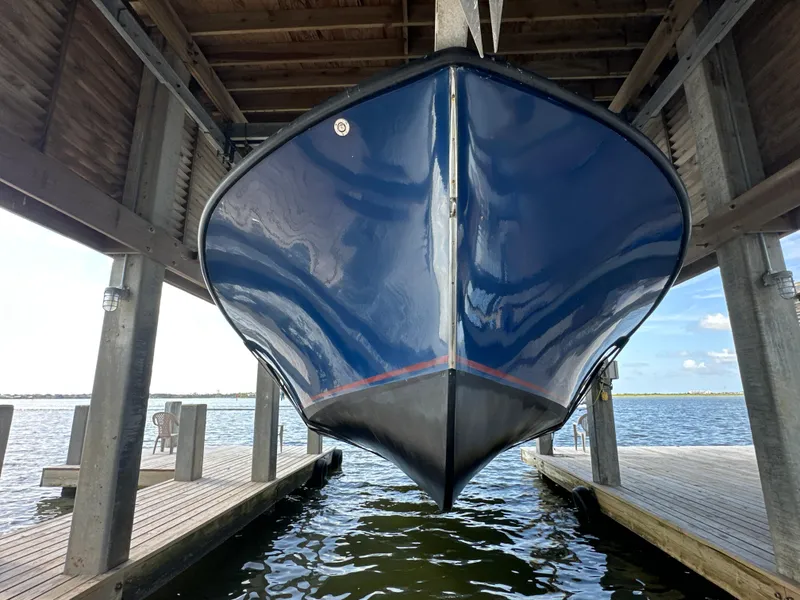 Slide: The Image of Blue Jefferson Fiberglass 32 Laffite Skiff boat suspended in a dock, 2004 model. - 7