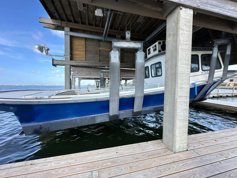 Slide: The Image of 2004 Jefferson Fiberglass 32 Laffite Skiff on lift at marina dock. - 8