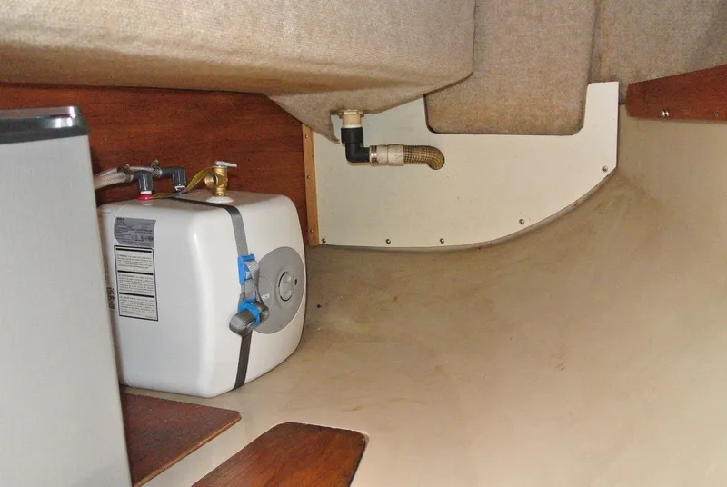 Slide: The Image of Interior of 1986 O'Day 272 sailboat showing water heater and plumbing. - 26