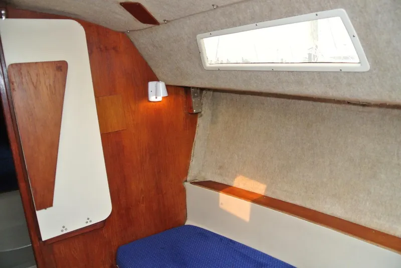 Slide: The Image of Interior of 1986 O'Day 272 sailboat with wooden paneling and blue seating. - 28