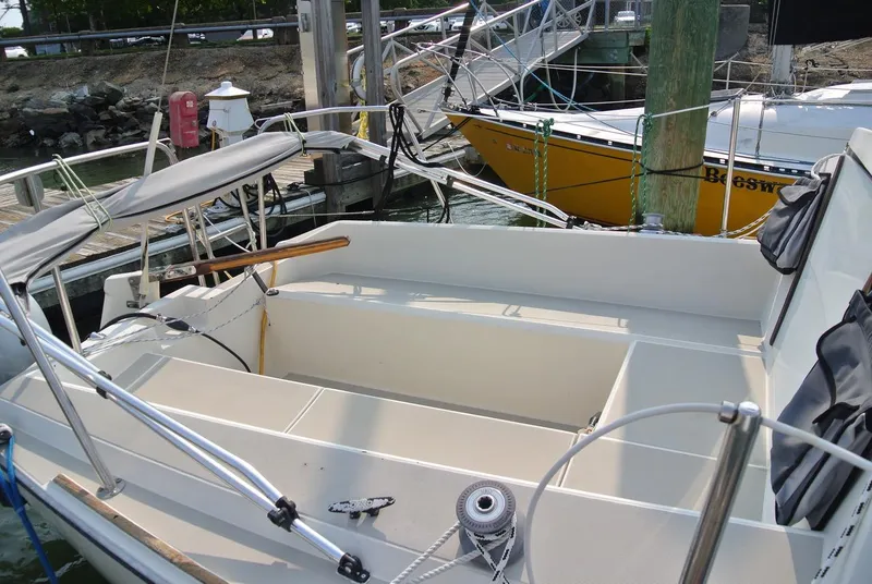 Slide: The Image of 1986 O'Day 272 sailboat cockpit with seating, docked near a yellow boat. - 4