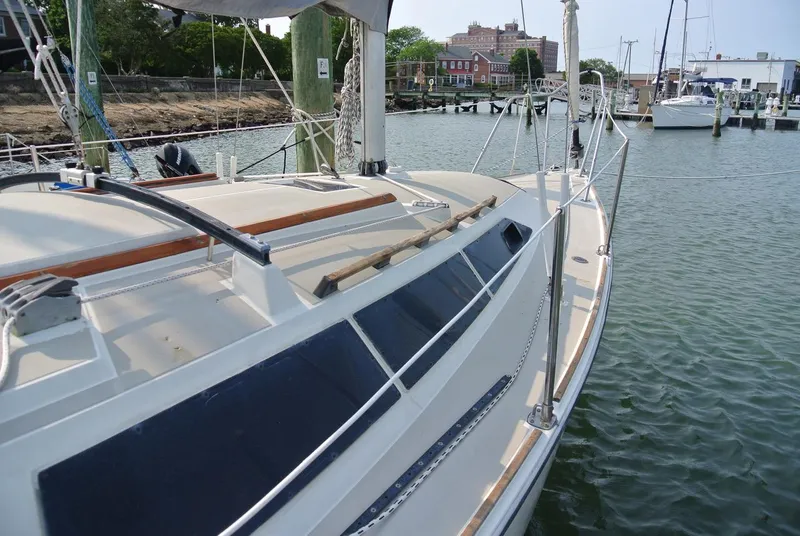 Slide: The Image of 1986 O'Day 272 sailboat docked in a marina, showcasing sleek design and spacious deck. - 5