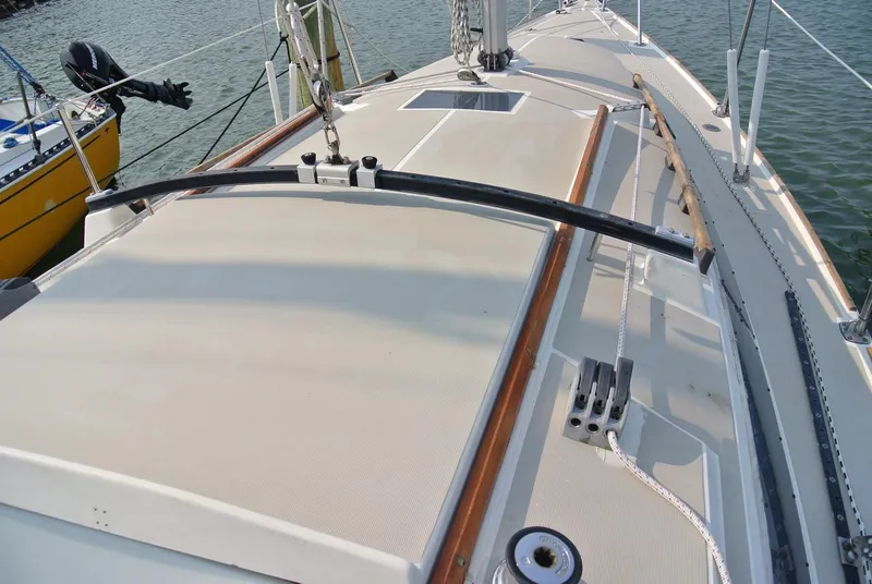 Slide: The Image of 1986 O'Day 272 sailboat deck with rigging and fittings, docked by the water. - 6