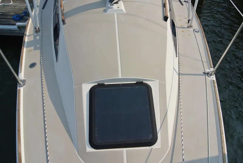 Slide: The Image of 1986 O'Day 272 sailboat deck with hatch, docked by the water. - 9