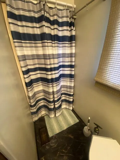 Slide: The Image of Bathroom in 1992 Jamestowner 16x72 houseboat with striped shower curtain and marble countertop. - 16