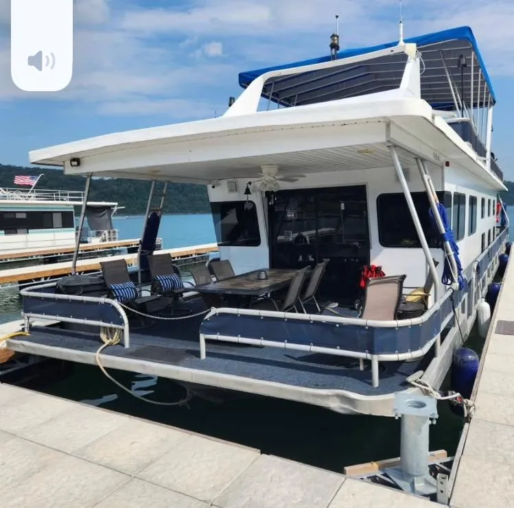 Slide: The Image of 1992 Jamestowner 16x72 houseboat docked with outdoor seating and blue canopy. - 2