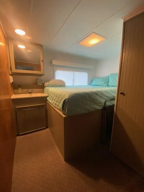 Slide: The Image of 1992 Jamestowner 16x72 houseboat bedroom with bed, sink, and storage. Cozy and compact design. - 22