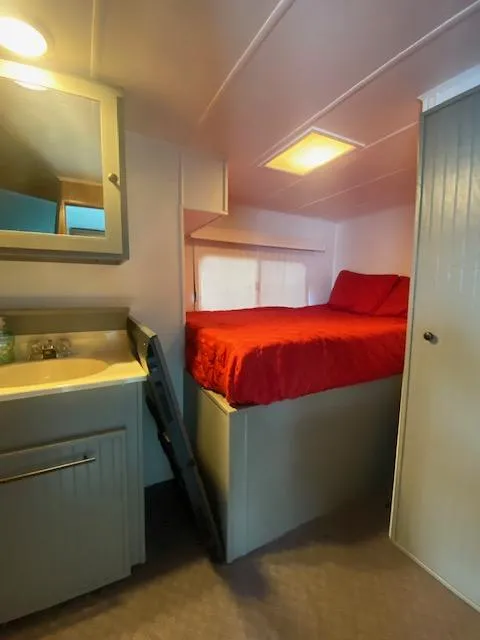 Slide: The Image of Interior of 1992 Jamestowner 16x72 houseboat with elevated bed and compact sink area. - 23