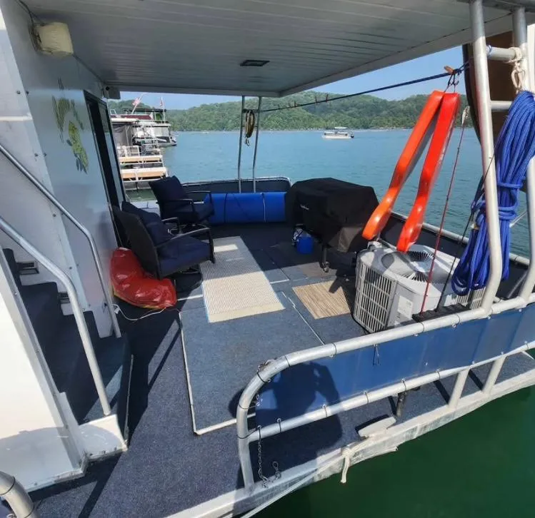 Slide: The Image of 1992 Jamestowner 16x72 houseboat deck with seating, life jackets, and scenic lake view. - 30