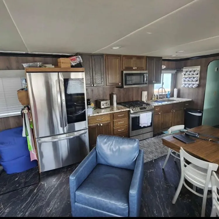 Slide: The Image of Interior of a 1992 Jamestowner 16x72 houseboat kitchen with modern appliances and seating area. - 8