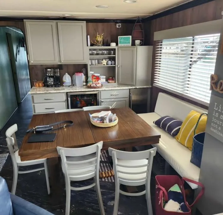 Slide: The Image of 1992 Jamestowner 16x72 houseboat interior with dining area, kitchen, and cozy seating. - 9