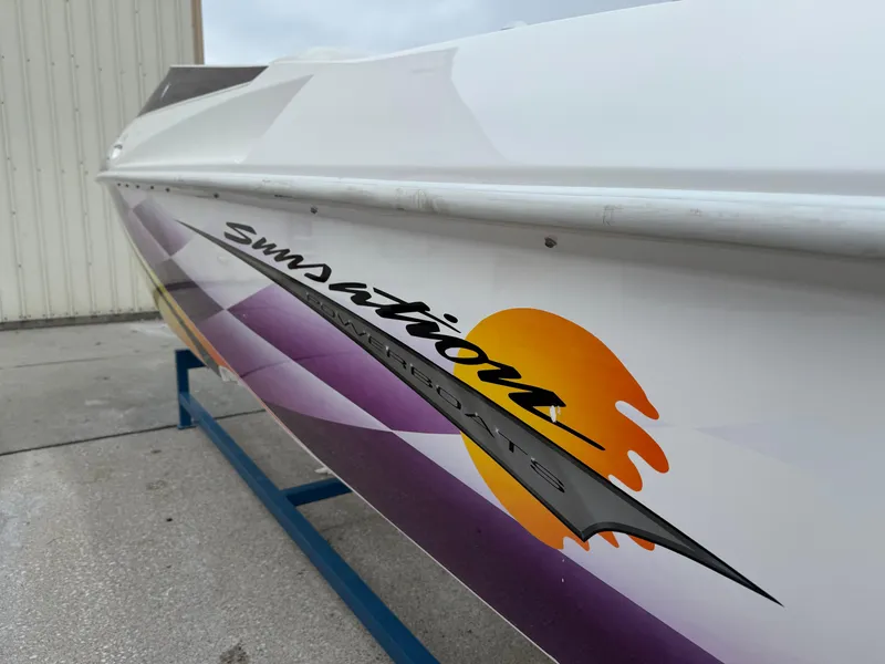 Slide: The Image of 2003 Sunsation 288 powerboat with vibrant graphics, displayed on a stand. - 12
