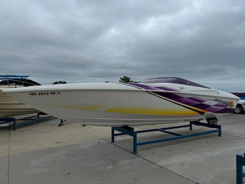 Slide: The Image of 2003 Sunsation 288 speedboat with purple and yellow design on a trailer. - 2