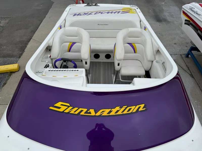 Slide: The Image of 2003 Sunsation 288 boat with white and purple interior, docked on pavement. - 20