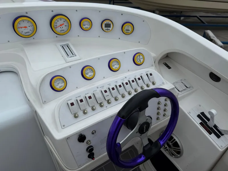 Slide: The Image of 2003 Sunsation 288 boat dashboard with gauges, switches, and a purple steering wheel. - 21