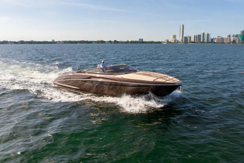 Slide: The Image of 2005 Riva 44' Rivarama luxury yacht cruising on open water near city skyline. - 18