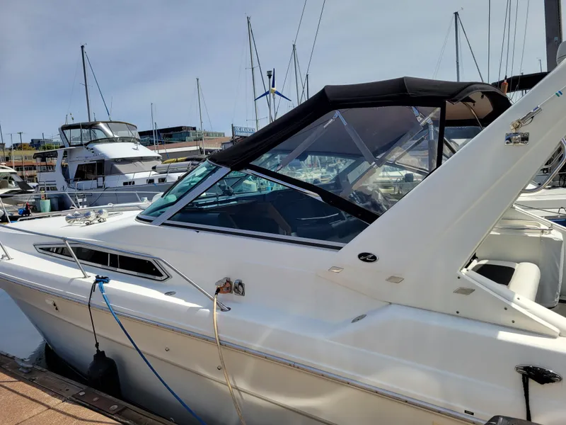 Slide: The Image of 1992 Sea Ray 330 Sundancer docked at marina, featuring sleek design and black canopy. - 3